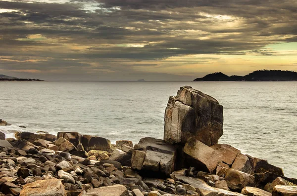 Grande pedra pontiaguda entre as formações rochosas junto ao mar — Fotografia de Stock