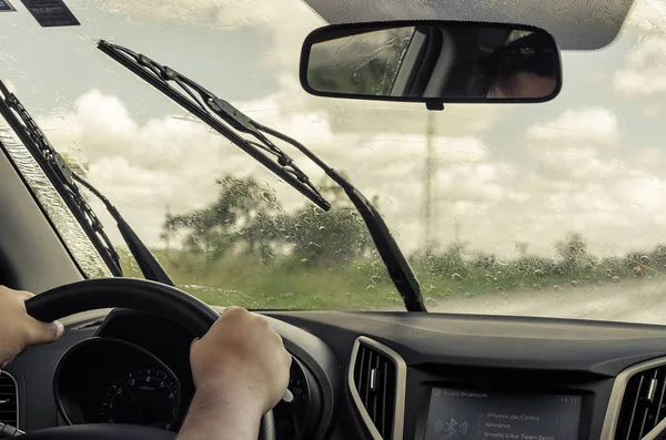 Dirigindo o carro na estrada em um dia chuvoso Imagens De Bancos De Imagens