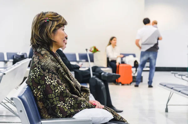 Mulher à espera sentada na sala de embarque do aeroporto — Fotografia de Stock