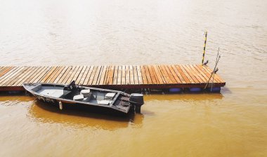 Ahşap dock üzerinde demirlemiş bir tekne ile.