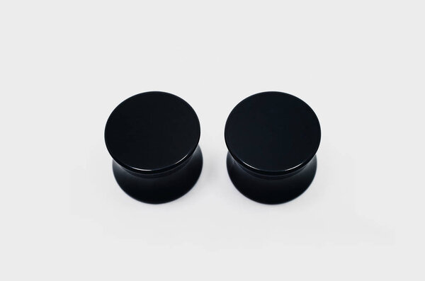 Pair of black ear plugs piercings, ear stretchers