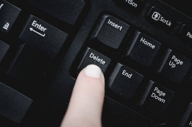 Parmak üzerinde tozlu siyah klavyeden delete tuşuna