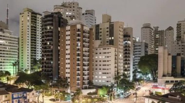 Sao Paulo 'nun gece vakti çekilmiş videosu. Bir metropolün yüksek binaları. Bulutlar hızlı hareket ediyor. Yüksek yoğunluklu bir yerleşim yerinin gece hayatı ve büyük bir şehrin trafiği.