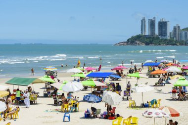 Sunbathers at Praia das Pitangueiras beach clipart