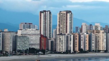 Gün batımında sahil kenti, şehrin ışıkları yanmaya başladığında. Paulista kıyısı, Sao Vicente şehri ile Santos şehri arasındaki sınır, Sp Brazil. 