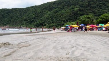 Guaruja - Sp, Brezilya - 20 Kasım 2019: Güneşli bir günde Praia do Guaiuba plajında güneşlenenler. Sahil sakin bir deniz ve birkaç dalga..