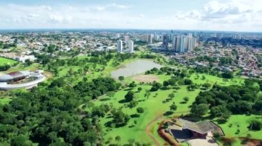 Campo Grande MS, Brezilya 'nın hızlı zoom videosu ve yerli ulusların parkı. Park, göl, yeşil alanlar ve düşük yoğunluklu binaları olan büyük ormanlık bir şehir. Hava görünümü.