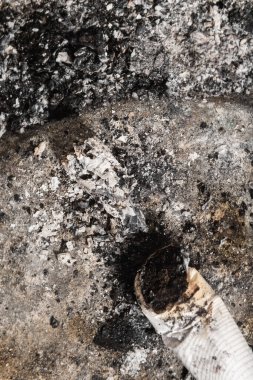 Smoked cigarette on the ashtray with ashes around. Cigarette butt and ashes.
