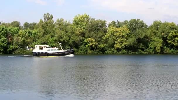 Een klein schip langs de rivier in beweging — Stockvideo