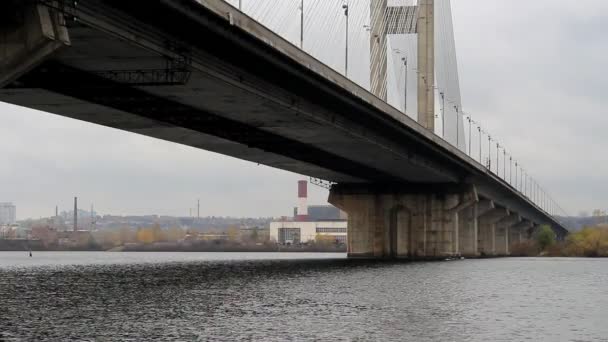 人と小さなボートは広い橋の下の川に沿って泳ぐ 張力ケーブル マシン ブリッジをサポートします — ストック動画