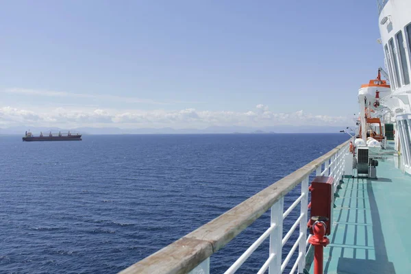 Geminin uzun güvertesi, güzel bir manzara ve denize doğru sürüklenen kocaman bir tanker..