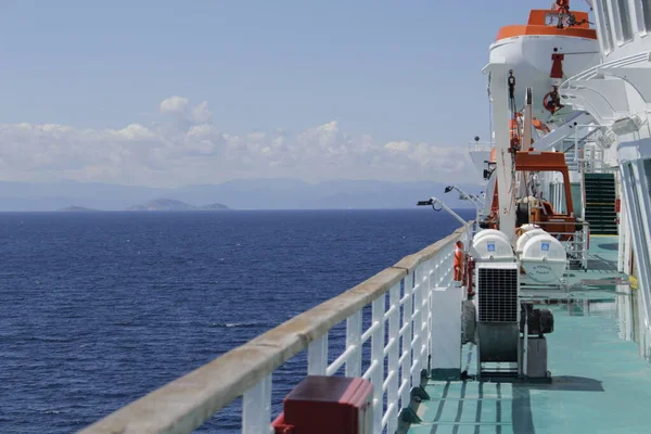 Tanker adanın kıyısına demir atmış, gövdesi pas içinde ve boyası soyulmuş, bu da eski bir gemi görüntüsü veriyor..