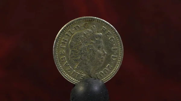 One pound English silver coin with the image of Elizabeth the second and the year of publication.