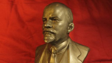 V.I. 'ın bakır büstü. Lenin kırmızı arka planda Sovyetler Birliği 'nin refah döneminin atmosferini taşır..