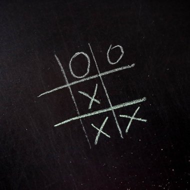 Tahtada tebeşir olan bir tic-tac-toe oyunu. Arkaplan