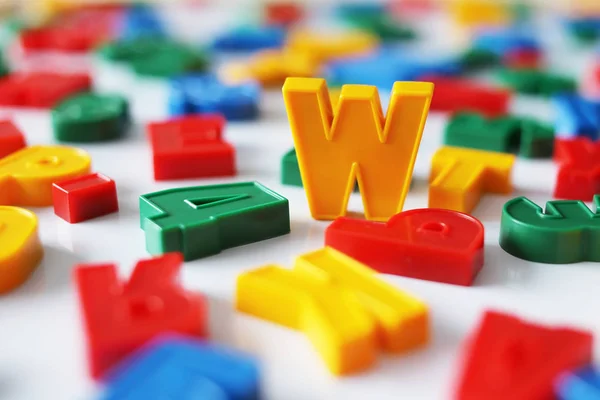 Letter W among the letters of the colorful alphabet on the magnet