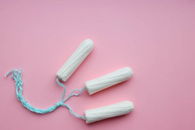 Pembe arka planda tıbbi kadın tamponları. Kadınlar için beyaz tampon. Regl, korunma aracı.