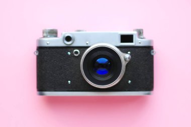 Pembe arka planda eski bir Retro film kamerası. Üst manzara, yumuşak minimum düz konum kompozisyonu. Yaz konsepti.
