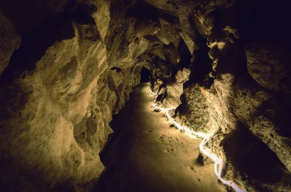 Прямая Подземная Тропа Каменной Пещере Освещенной Желтым Светом Стеной Камня — стоковое фото