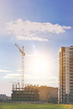 İnşaat vinç ve bir bina konut. Gökyüzü, bulutlar, güneş ışığı