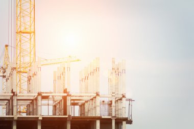 İnşaat vinç ve bir bina konut mavi bulutlu gökyüzü güneş ile karşı