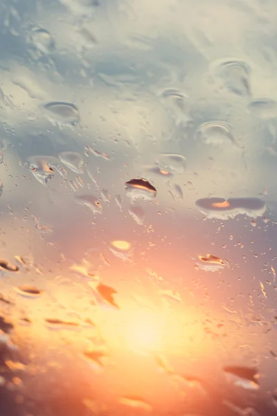 Rain water drops with sun  on glass  background