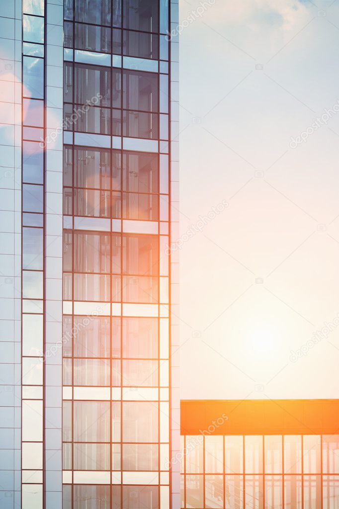 Skyscraper reflection of the glass . Blue sky with sun background