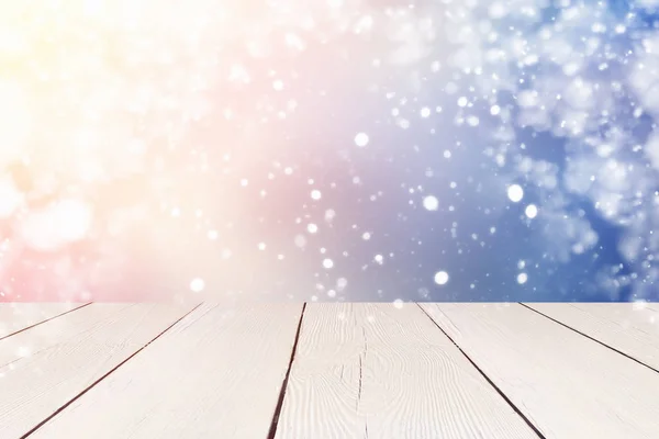 Fiocchi di neve bokeh con luce del sole e tavolo. Sfondo natalizio. Utilizzare per il montaggio o visualizzare i prodotti — Foto Stock