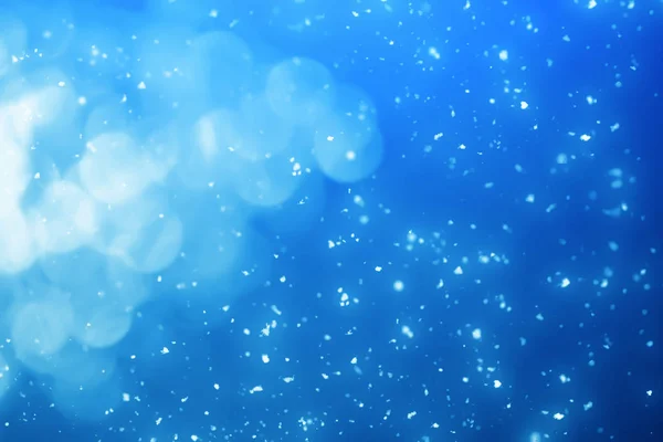 Weihnachten festlichen Hintergrund. Blaues Licht und Bokeh-Teilchen — Stockfoto