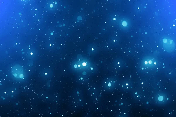 Bokeh e particelle sfocate su sfondo astratto blu. Buon Natale modello — Foto Stock