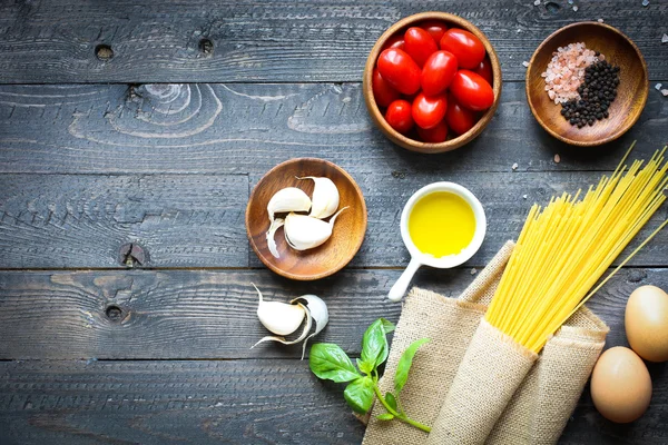 Vista superior de ingredientes italianos para tomate e espaguete basílico — Fotografia de Stock