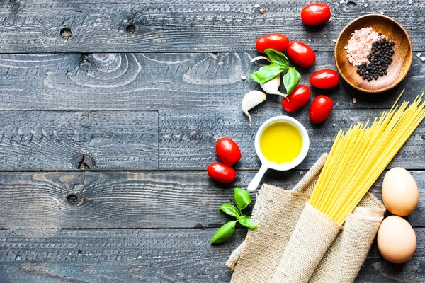 Vue du dessus des ingrédients italiens pour la tomate et spaghetti basilique — Photo