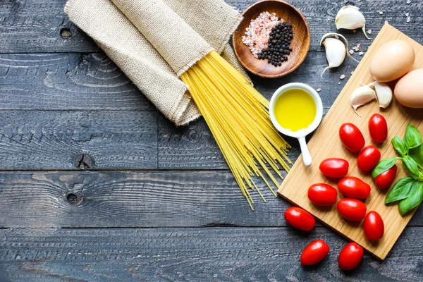 Vista superior de ingredientes italianos para tomate e espaguete basílico — Fotografia de Stock
