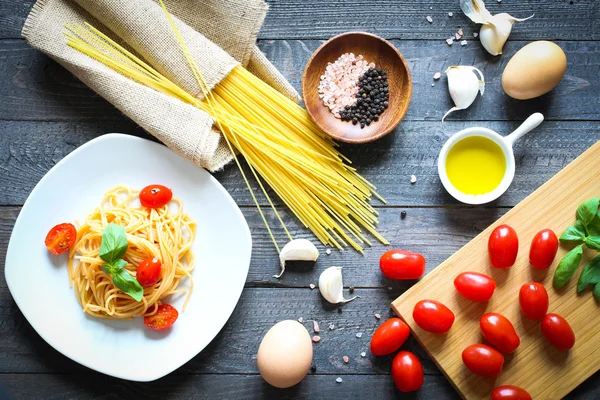 Vista superior de los ingredientes italianos para tomate y espaguetis basilic —  Fotos de Stock