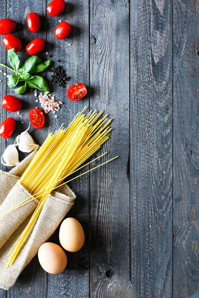 Vista superior de ingredientes italianos para tomate e espaguete basílico — Fotografia de Stock