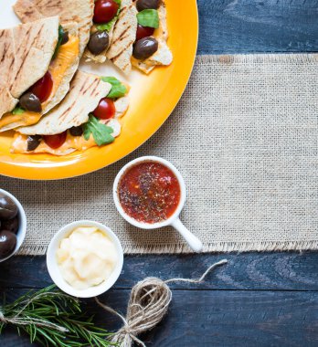 Lezzetli sebzeli omlet domates, zeytin ve bir tahta üzerinde renkli bir tabak içinde kaşar peyniri ile