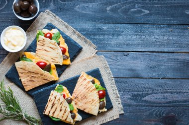 Lezzetli sebzeli omlet domates, zeytin ve bir tahta üzerinde renkli bir tabak içinde kaşar peyniri ile