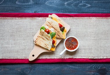 Lezzetli sebzeli omlet domates, zeytin ve bir tahta üzerinde renkli bir tabak içinde kaşar peyniri ile