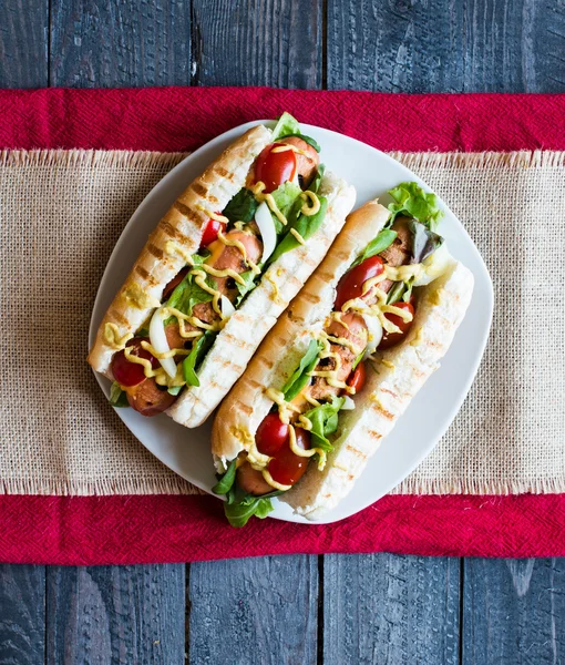 Hot dog with pickles, tomatoes and olives — Stockfoto