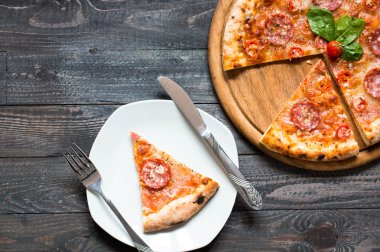 Rustik ahşap bir masa üzerinde sıcak İtalyan pizza.