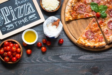 Rustik ahşap bir masa üzerinde sıcak İtalyan pizza.