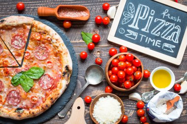 Rustik ahşap bir masa üzerinde sıcak İtalyan pizza.