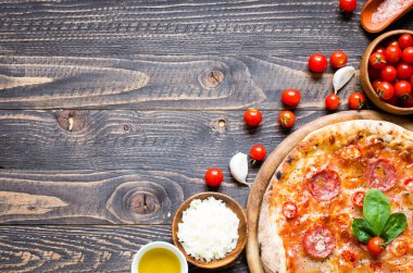 Rustik ahşap bir masa üzerinde sıcak İtalyan pizza.