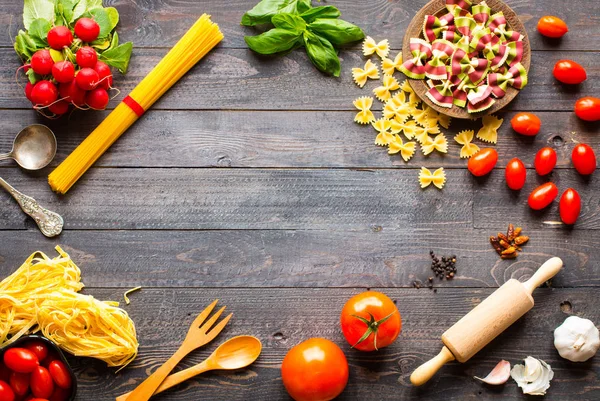 Fondo de pasta. Varios tipos de pasta seca con verduras, y —  Fotos de Stock