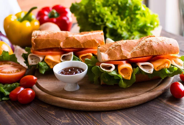 Deliciosos y sabrosos sándwiches con pavo, jamón, queso, tomate — Foto de Stock