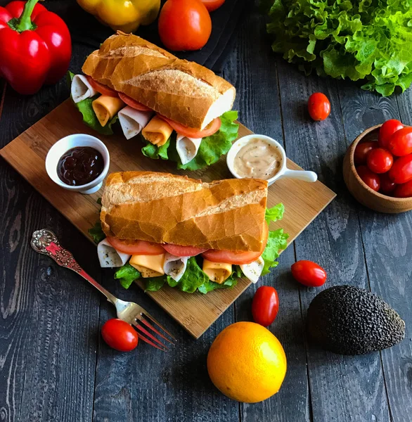 Смачні та смачні бутерброди з індичкою, шинкою, сиром, помідорами — стокове фото