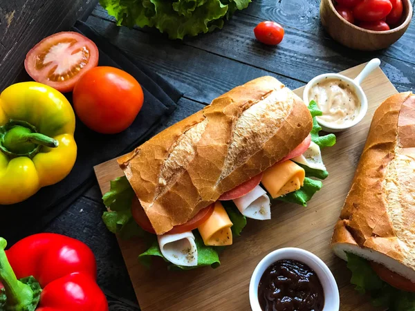 Вкусные и вкусные сэндвичи с индейкой, ветчиной, сыром, помидорами — стоковое фото
