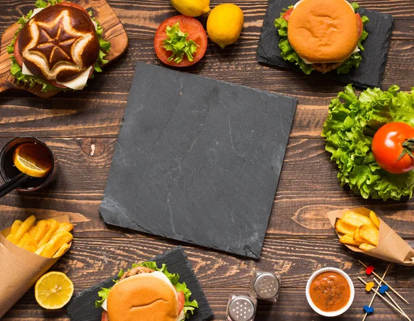 Blick von oben auf köstlichen Hamburger mit Gemüse auf einem Holztisch — Stockfoto