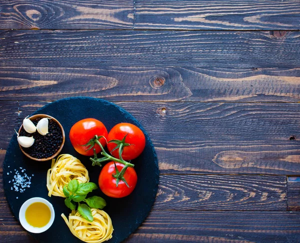 Tagliatelle z pomidorami i bazylią, wykonane w domu, na drewniane bac — Zdjęcie stockowe