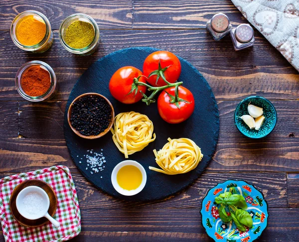 Tagliatelle com tomate e manjericão, feito em casa, sobre um bac de madeira — Fotografia de Stock